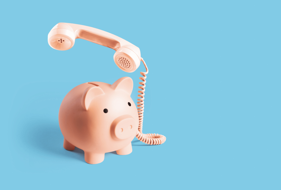 A pink piggy bank with a telephone receiver floating above it against a solid blue background.