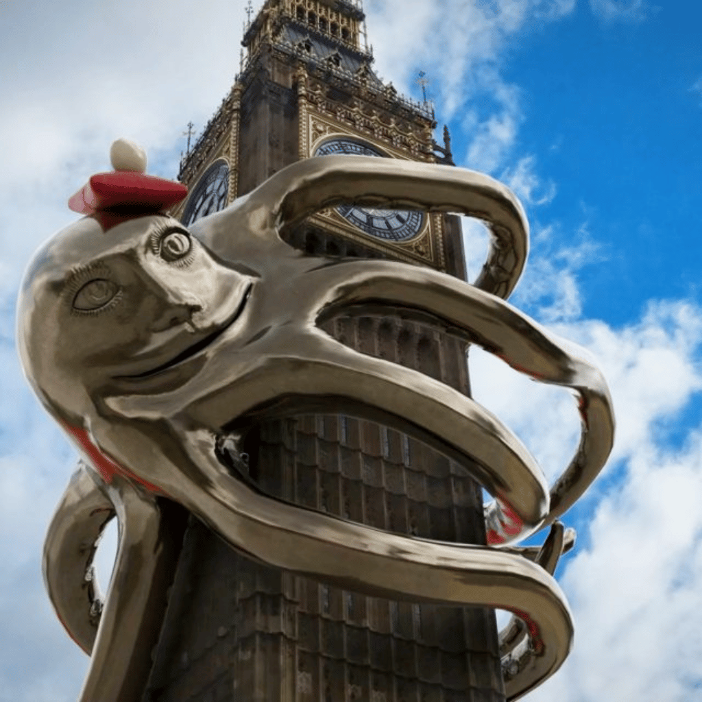 An augmented reality octopus whimsically adorned with a red hat, playfully wraps its tentacles around the iconic Big Ben in London, creating a surreal and engaging visual fusion.