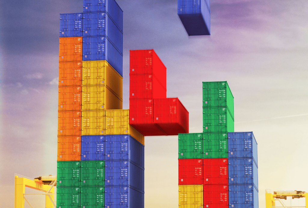 Colorful stacked shipping containers arranged in a playful, Tetris-like formation against a twilight sky.