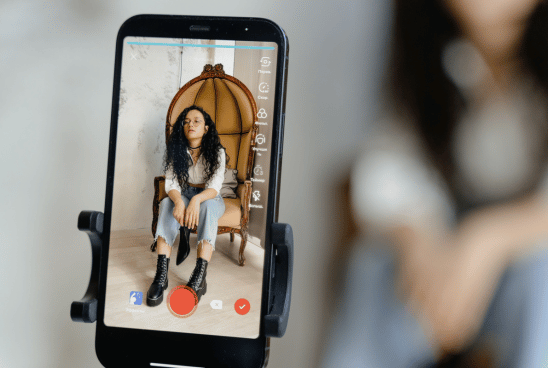 Smartphone on a tripod capturing a young woman creating content, highlighting the active participation of Gen Z in shaping the TikTok search culture.