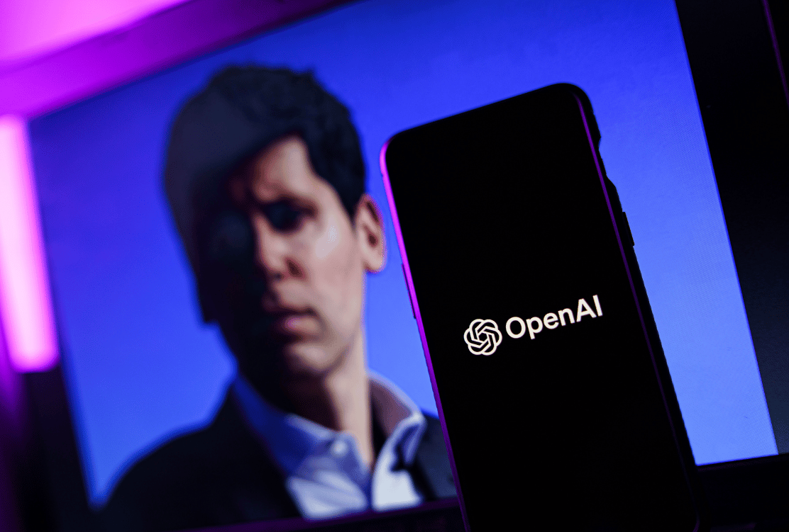 A smartphone displaying the OpenAI logo in the foreground with a blurred figure, presumably Sam Altman, in the background against a neon-lit backdrop.