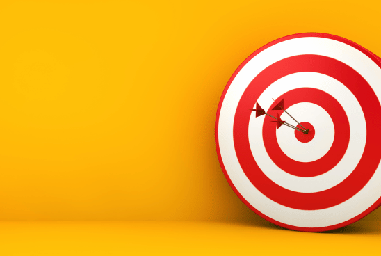 An arrow hitting the bullseye on a target against a bright yellow background.