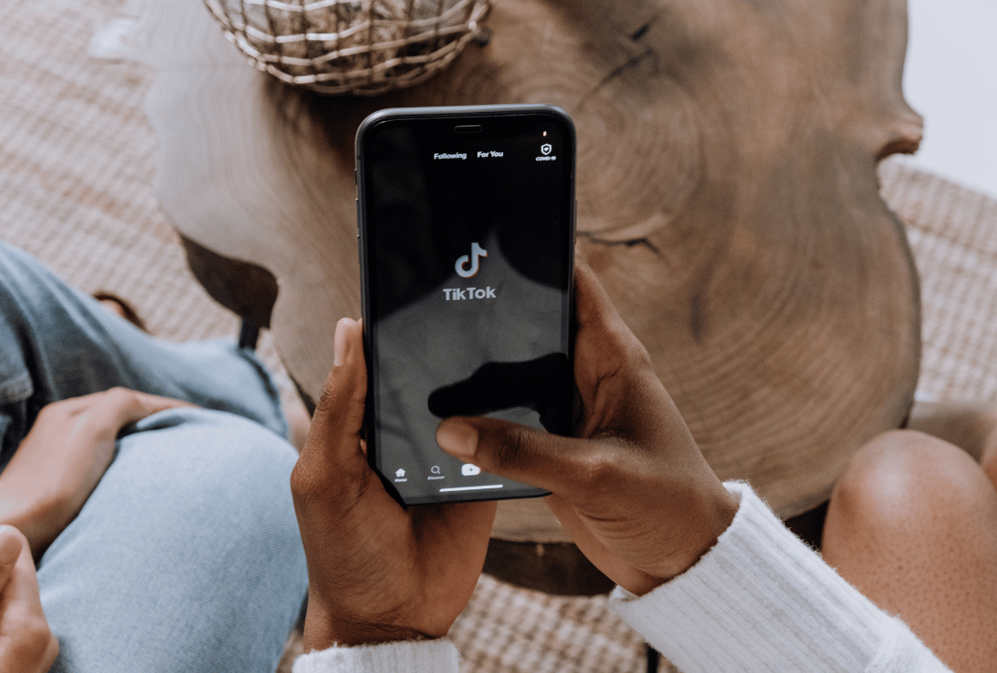 Close-up of a person's hands holding a smartphone with the TikTok app open, ready to search, symbolizing Gen Z's preference for TikTok as a search platform.