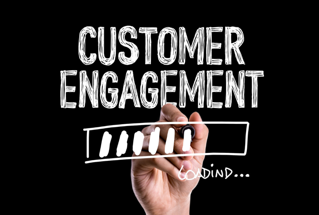 A hand drawing a progress bar under the words 'CUSTOMER ENGAGEMENT' written in white chalk style on a black background.