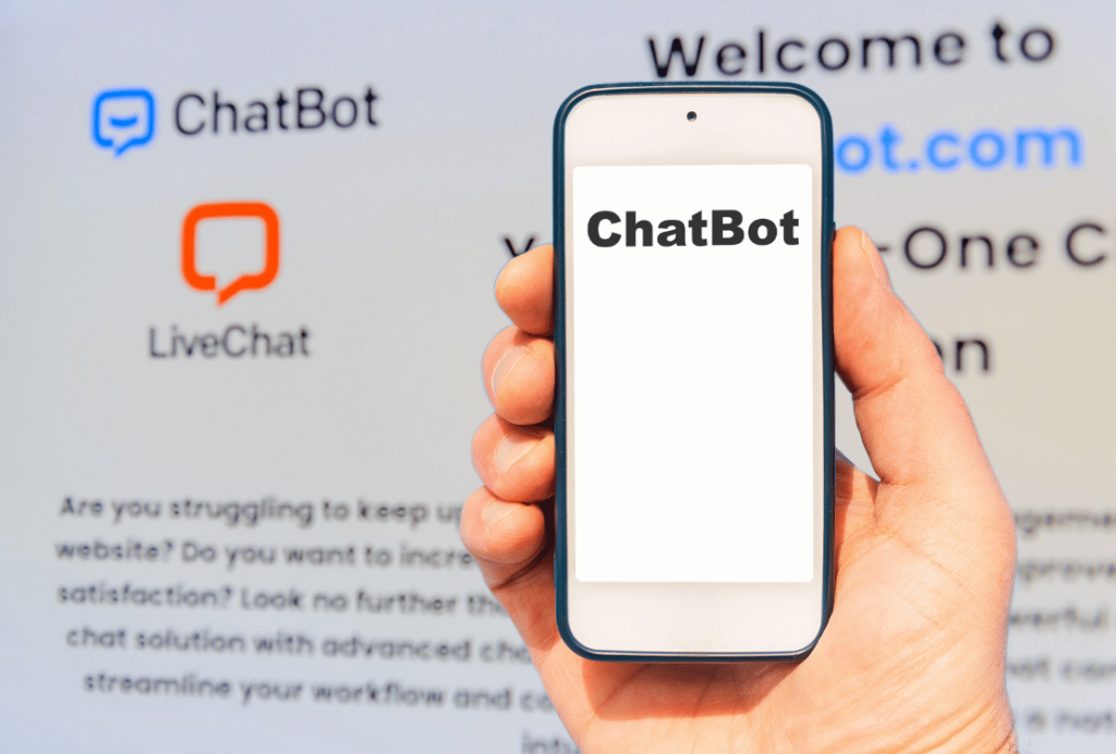 A hand holding a smartphone with the screen displaying 'ChatBot', in front of a background with the ChatBot website.